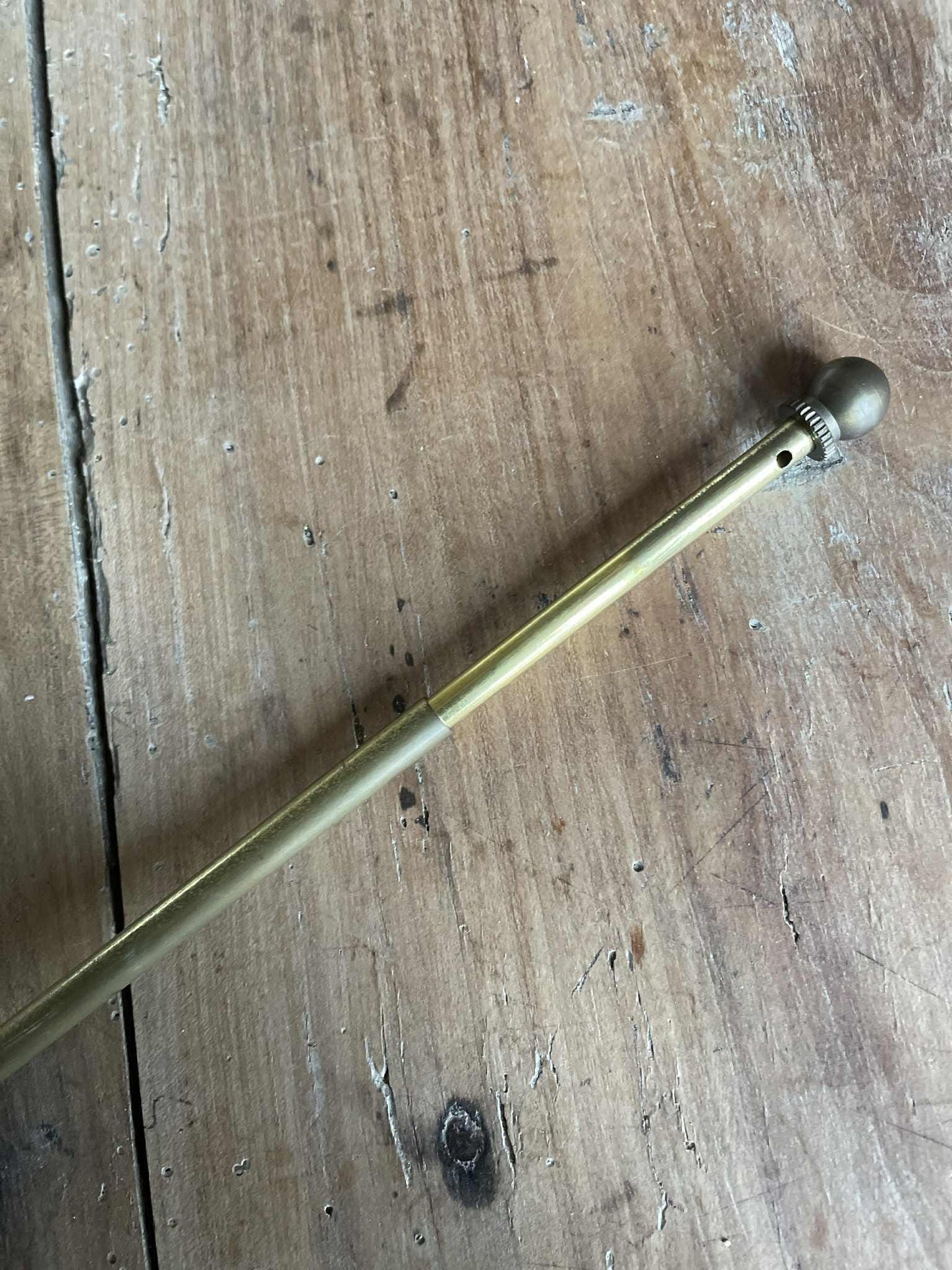 A single extendable brass lightweight curtain rod 58cm to 80cm max 7mm diameter