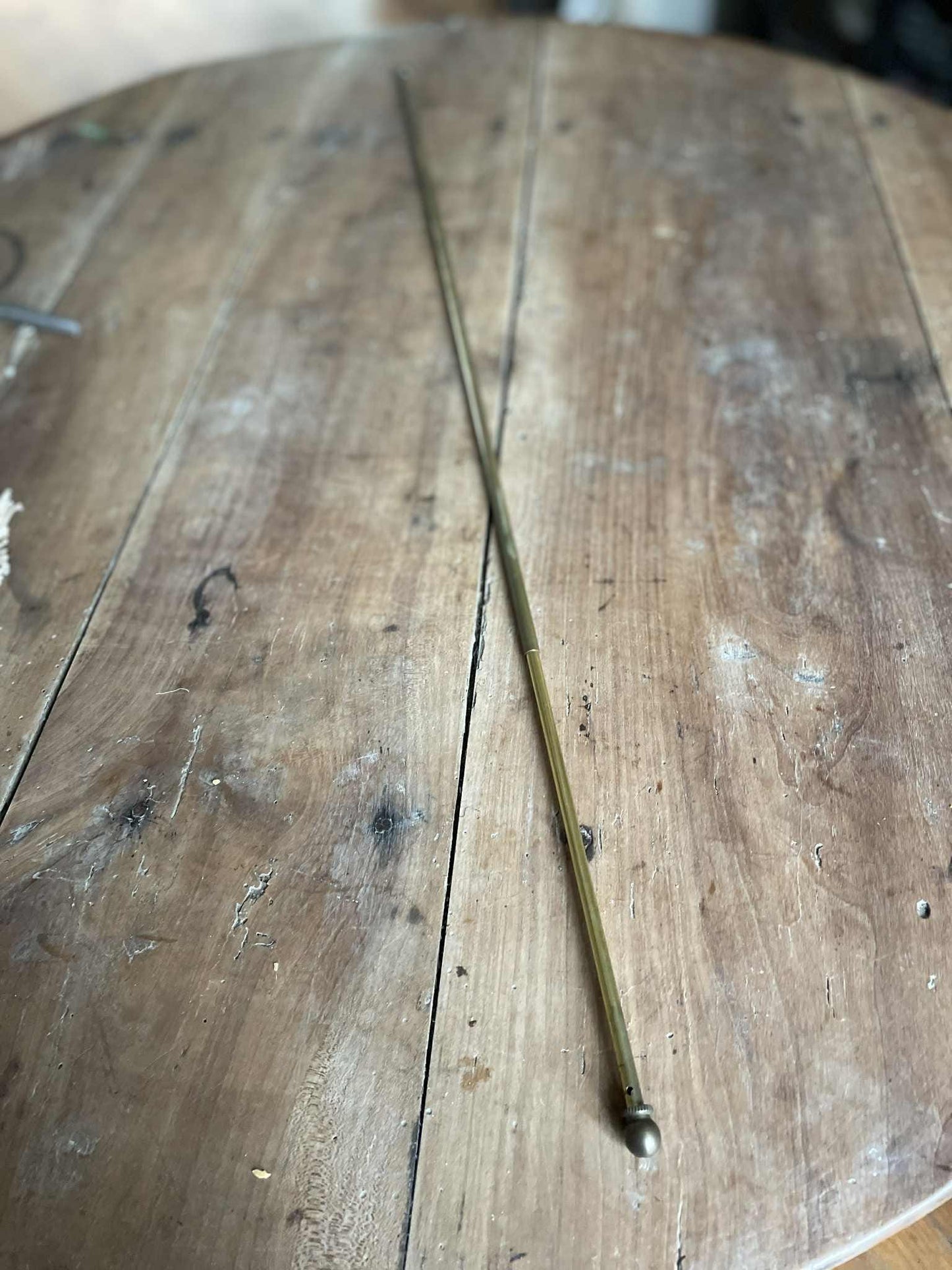 A single extendable brass lightweight curtain rod 58cm to 80cm max 7mm diameter