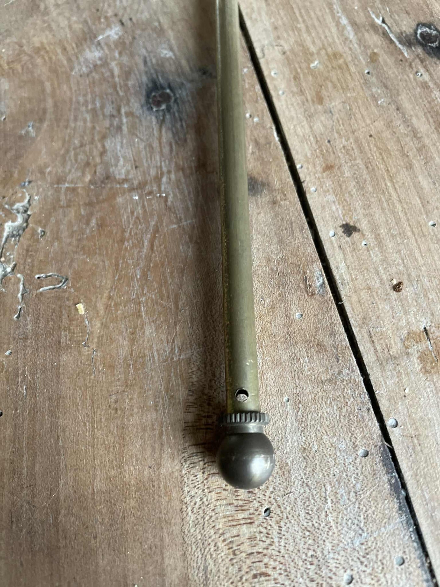 A single extendable brass lightweight curtain rod 58cm to 80cm max 7mm diameter